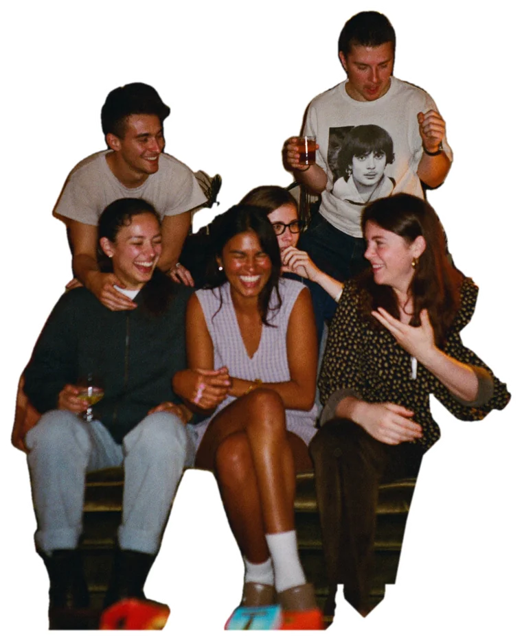 A group of friends laughing together in a living room